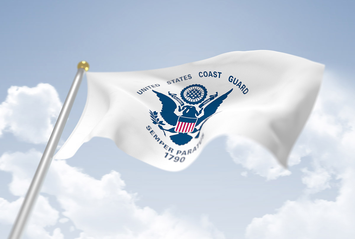 White flag with U.S. Coast Guard Logo on it flying in the sky
